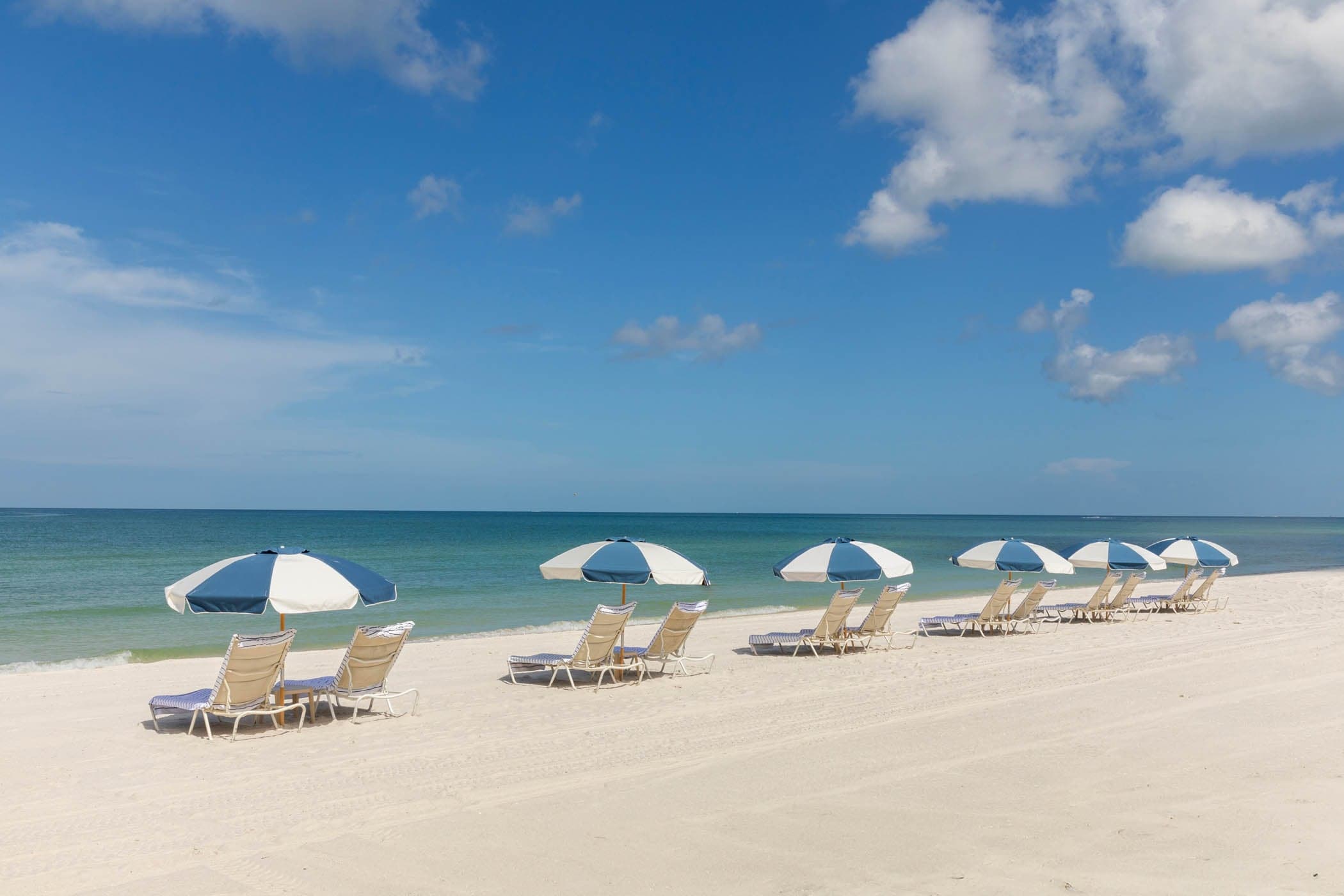 12 beach lounge chairs and umbrellas on the beach at LaPlay