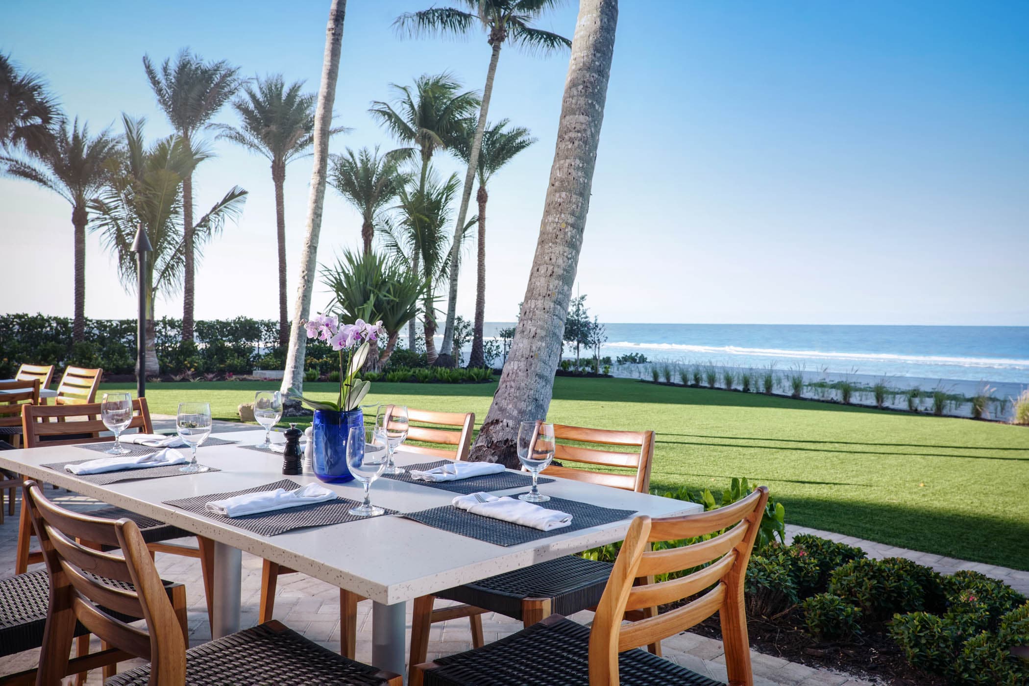 A table on a patio with a view of the yard and beach area at LaPlaya