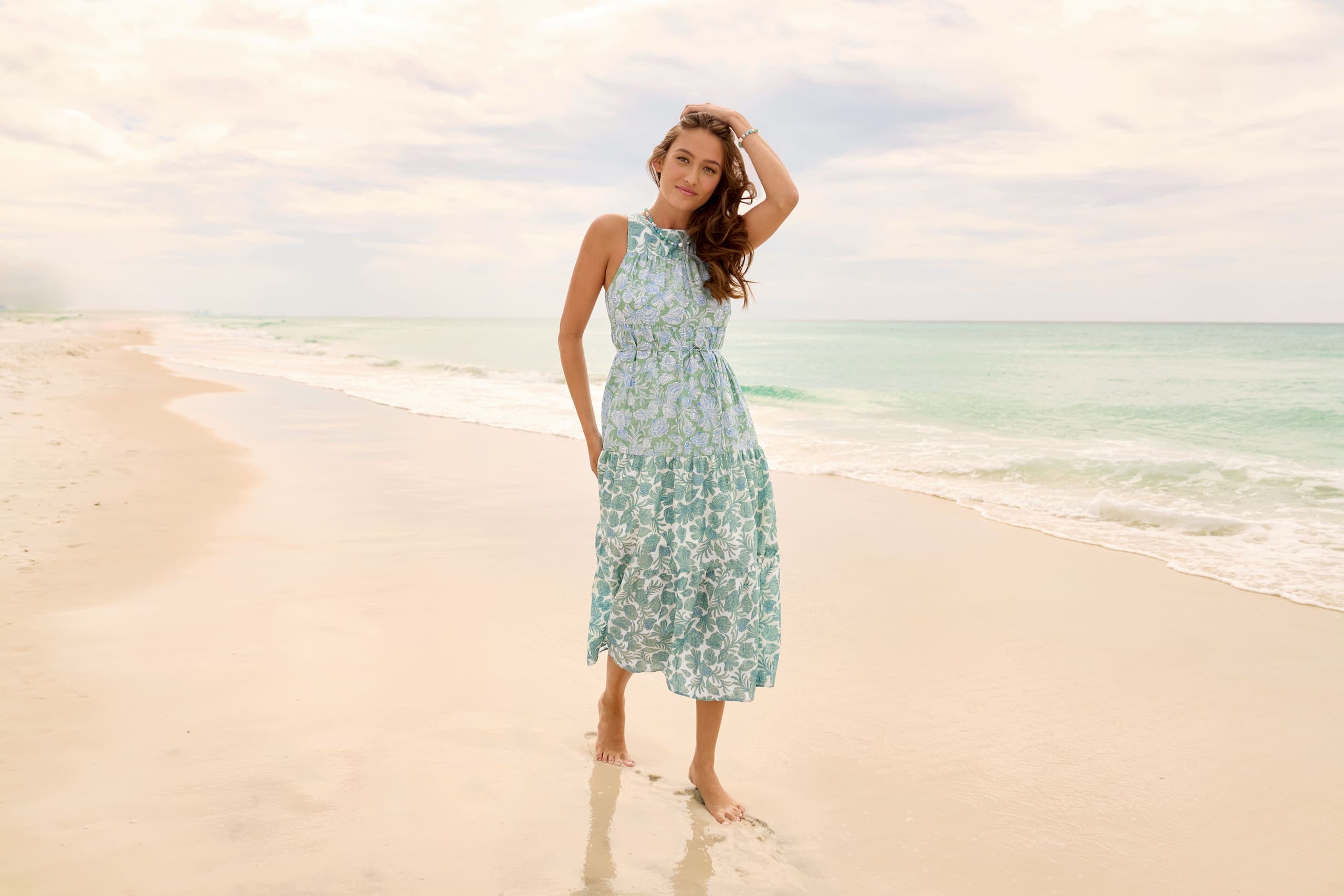 A woman in a green dress on the beach
