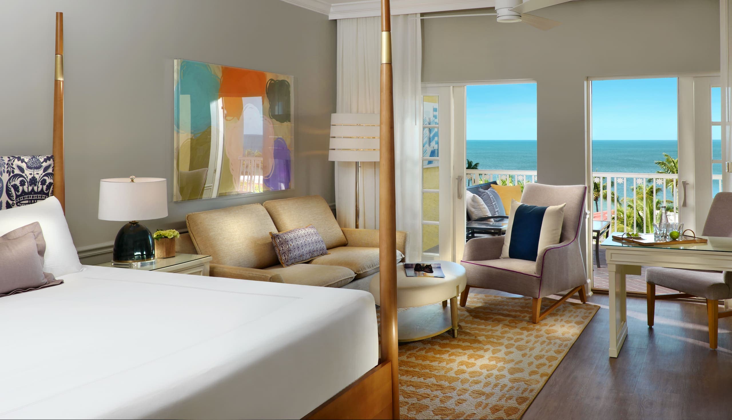 LaPlaya Bay Tower room with a living space, bed, and balcony looking over the water