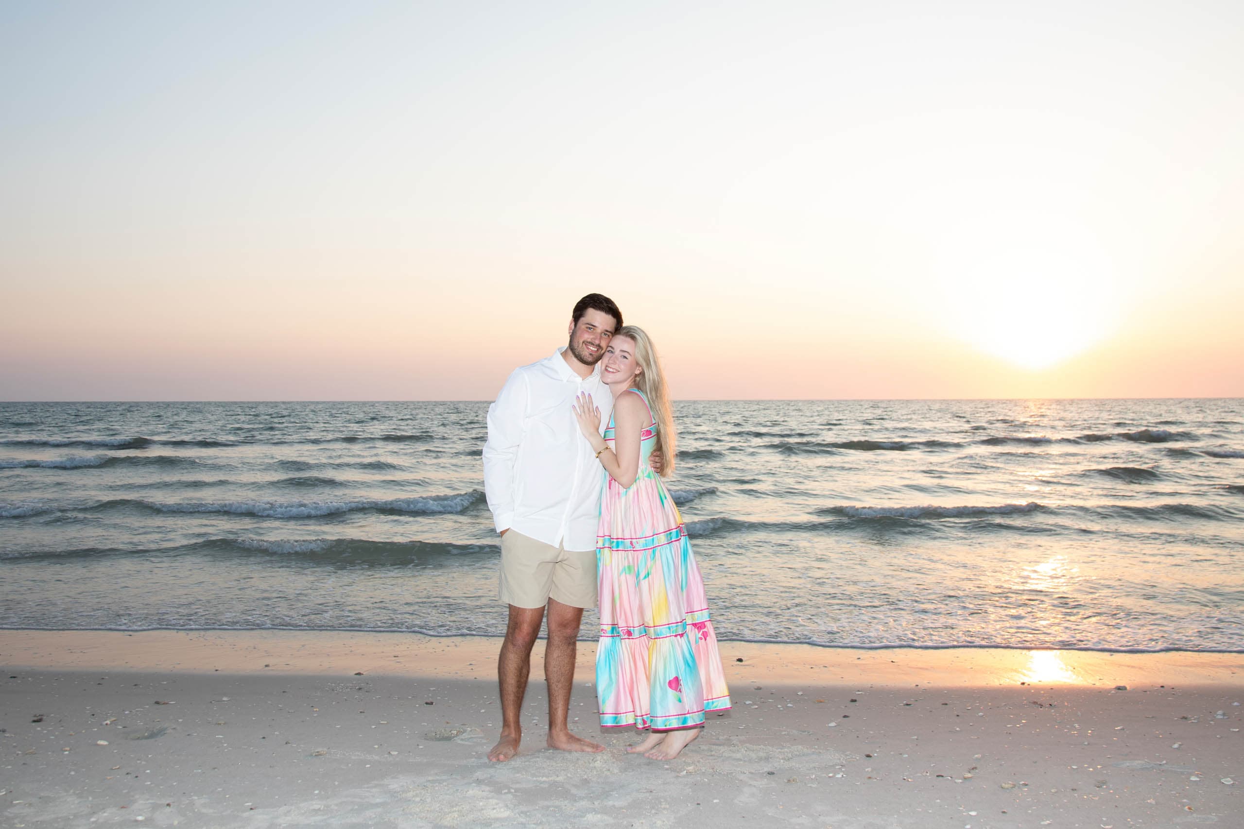 a couple on a beach at sunset