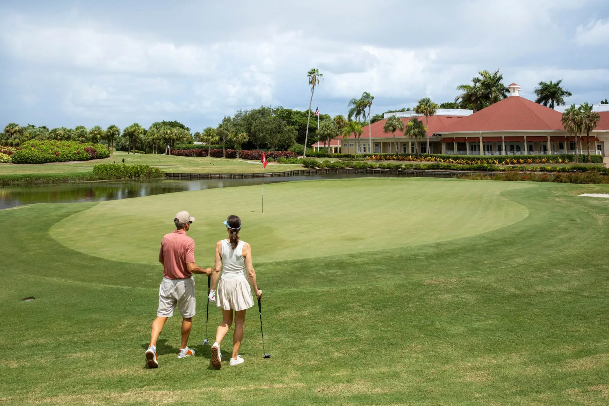 A man and woman walking on to the green at the golf course
