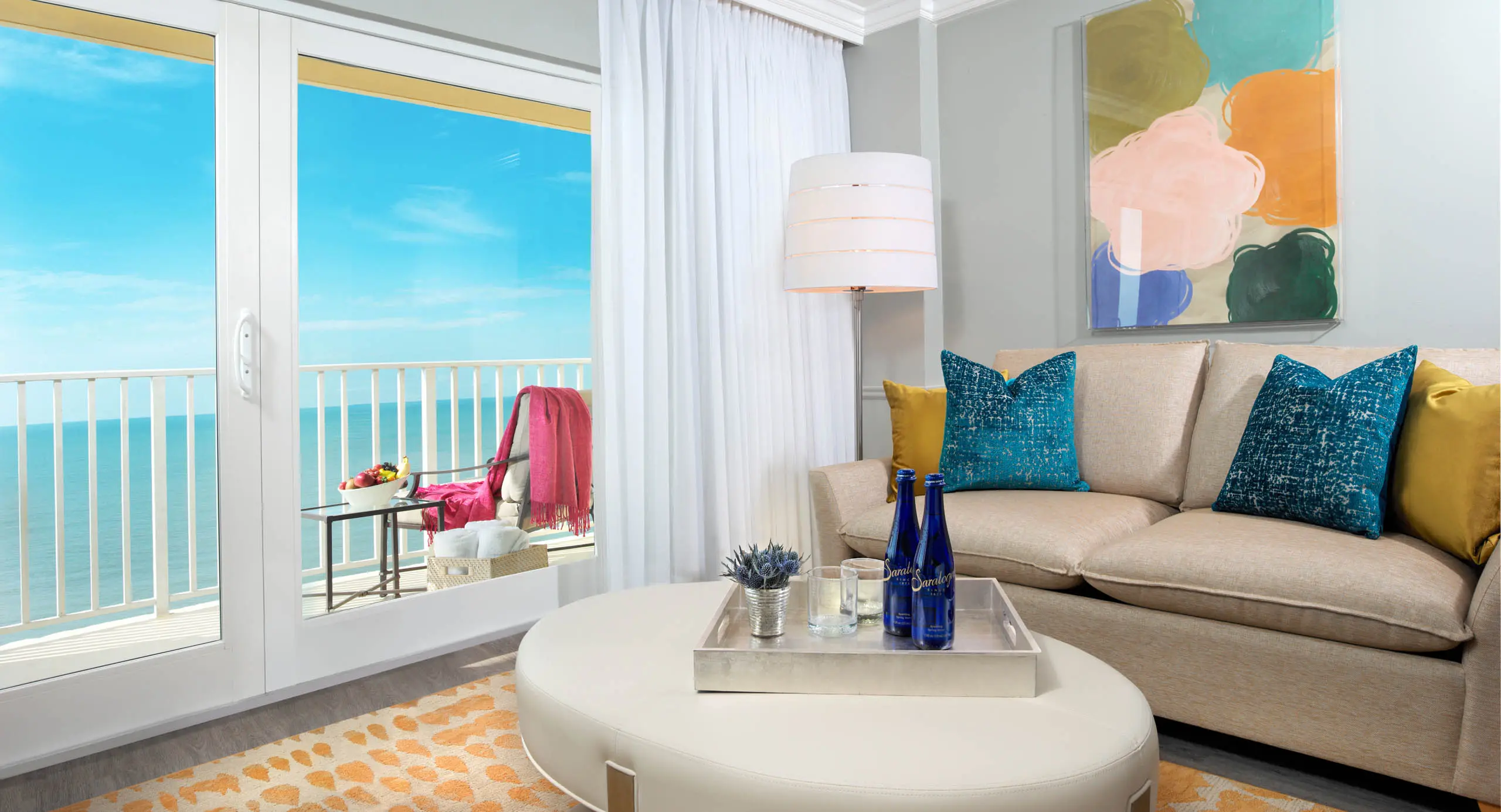 A room with a view of the water and a balcony