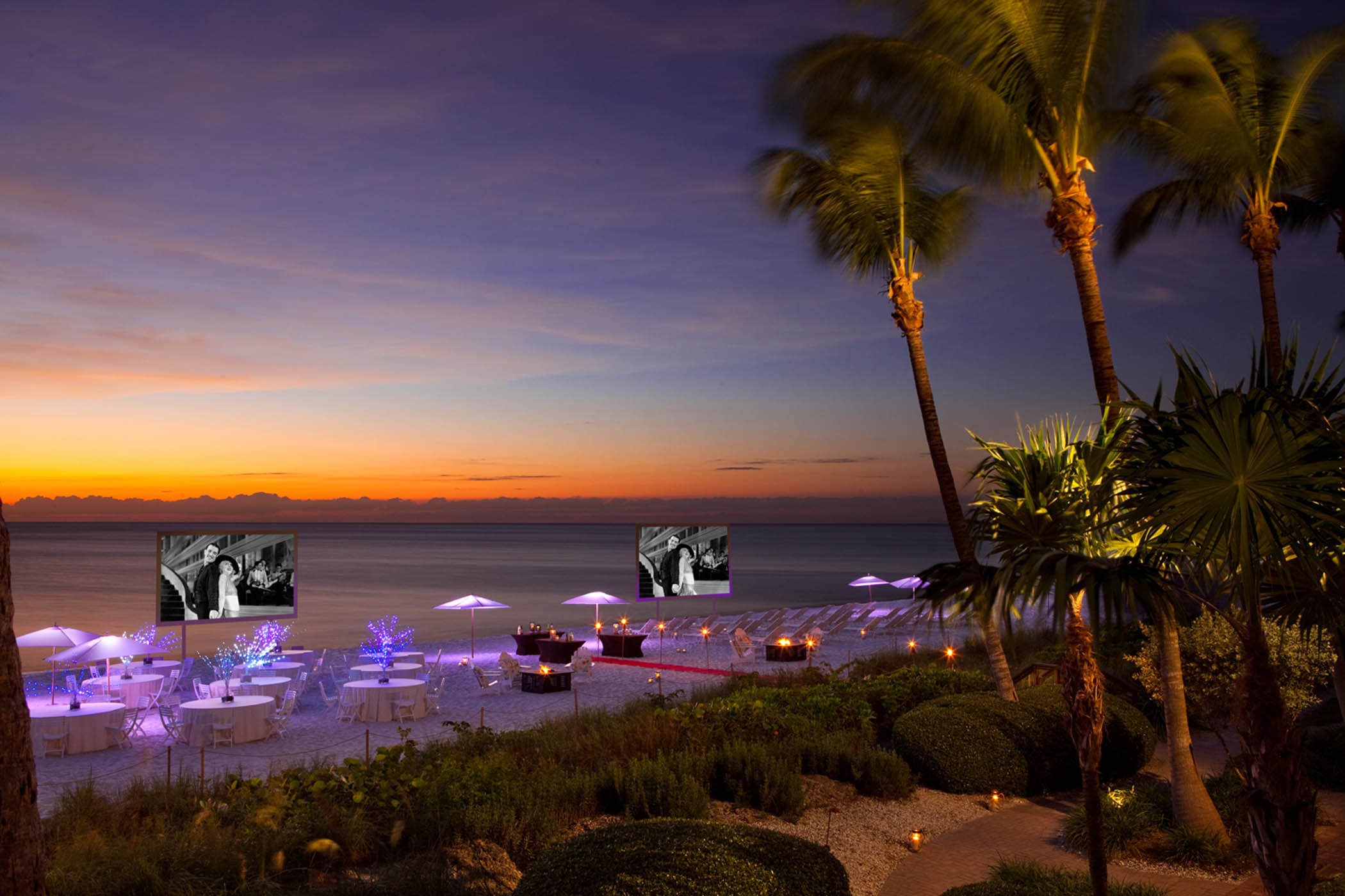 A function on the beach with 2 large screens