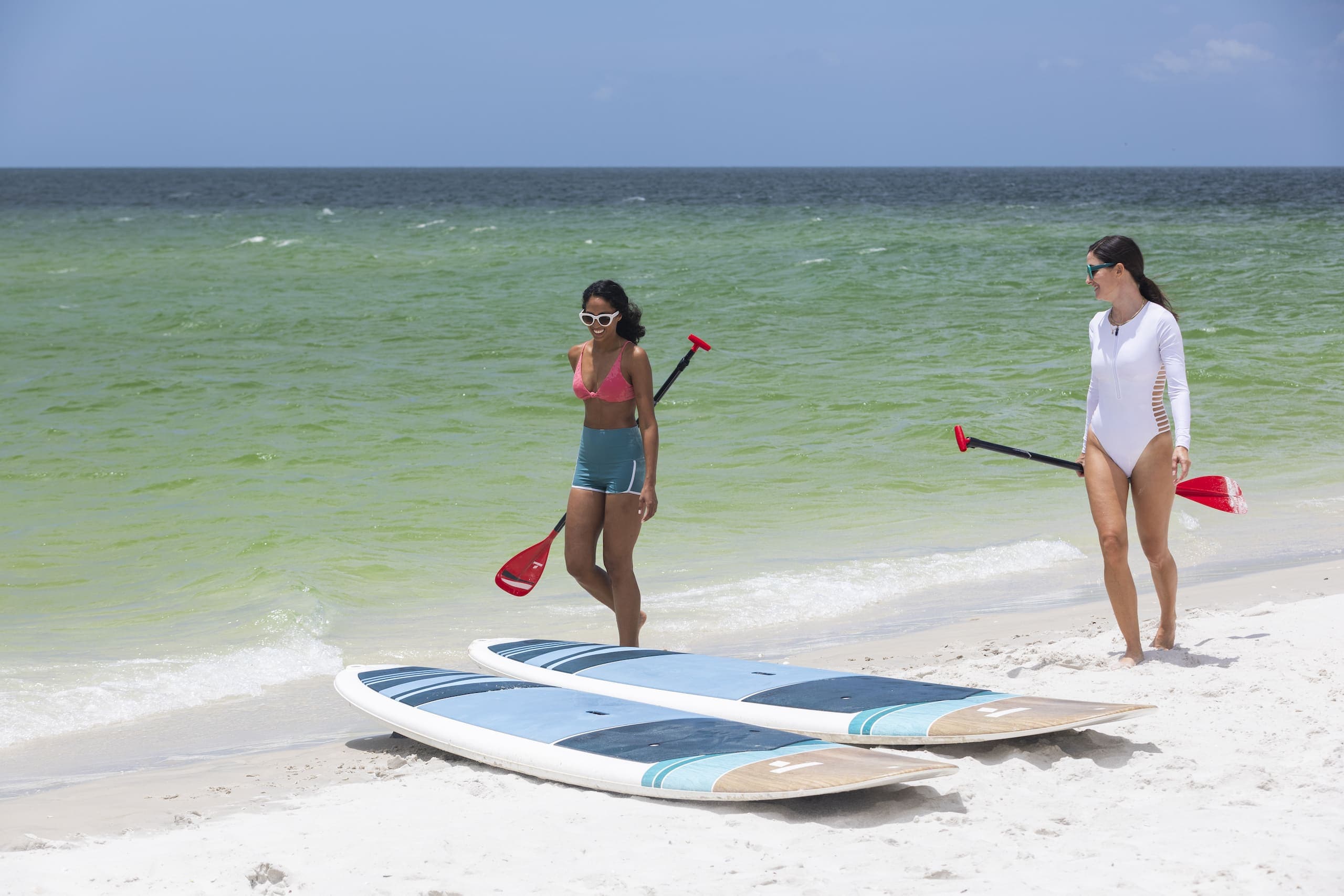 Two women getting ready to paddle board