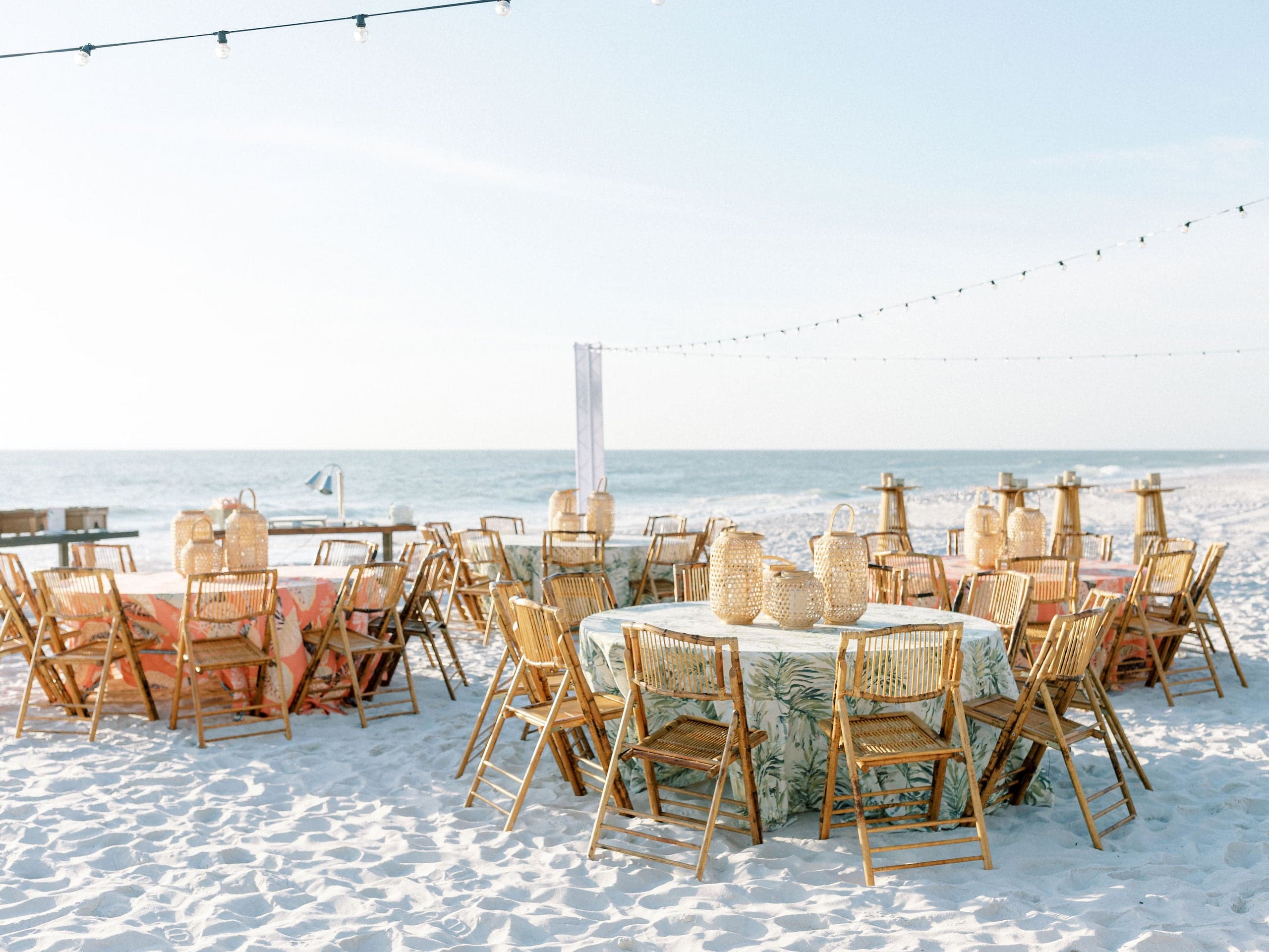 4 Tables setup with 8 chairs on the beach for a function at LaPlaya