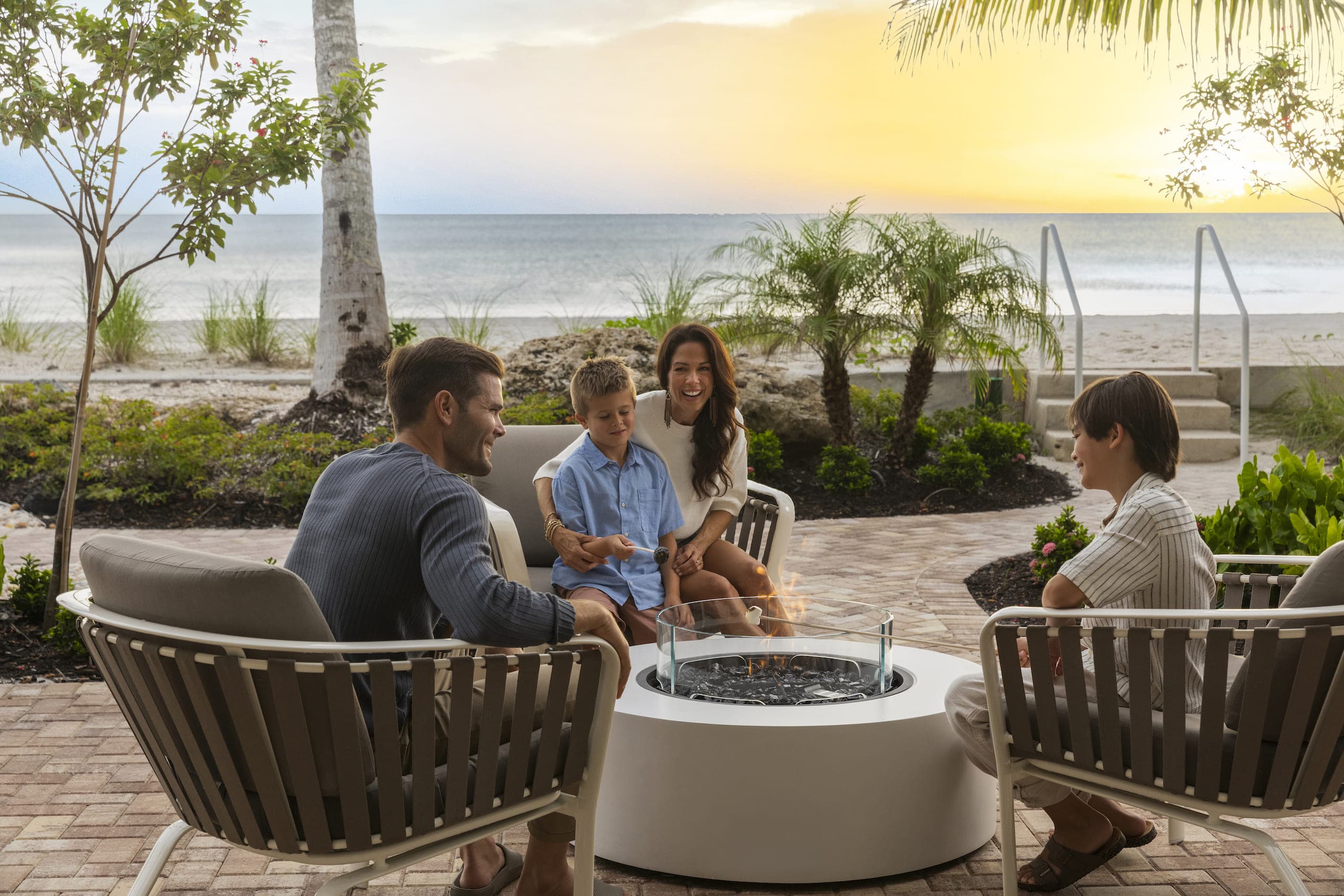 A family at LaPlaya roasting marshmallows outside at the fire pit