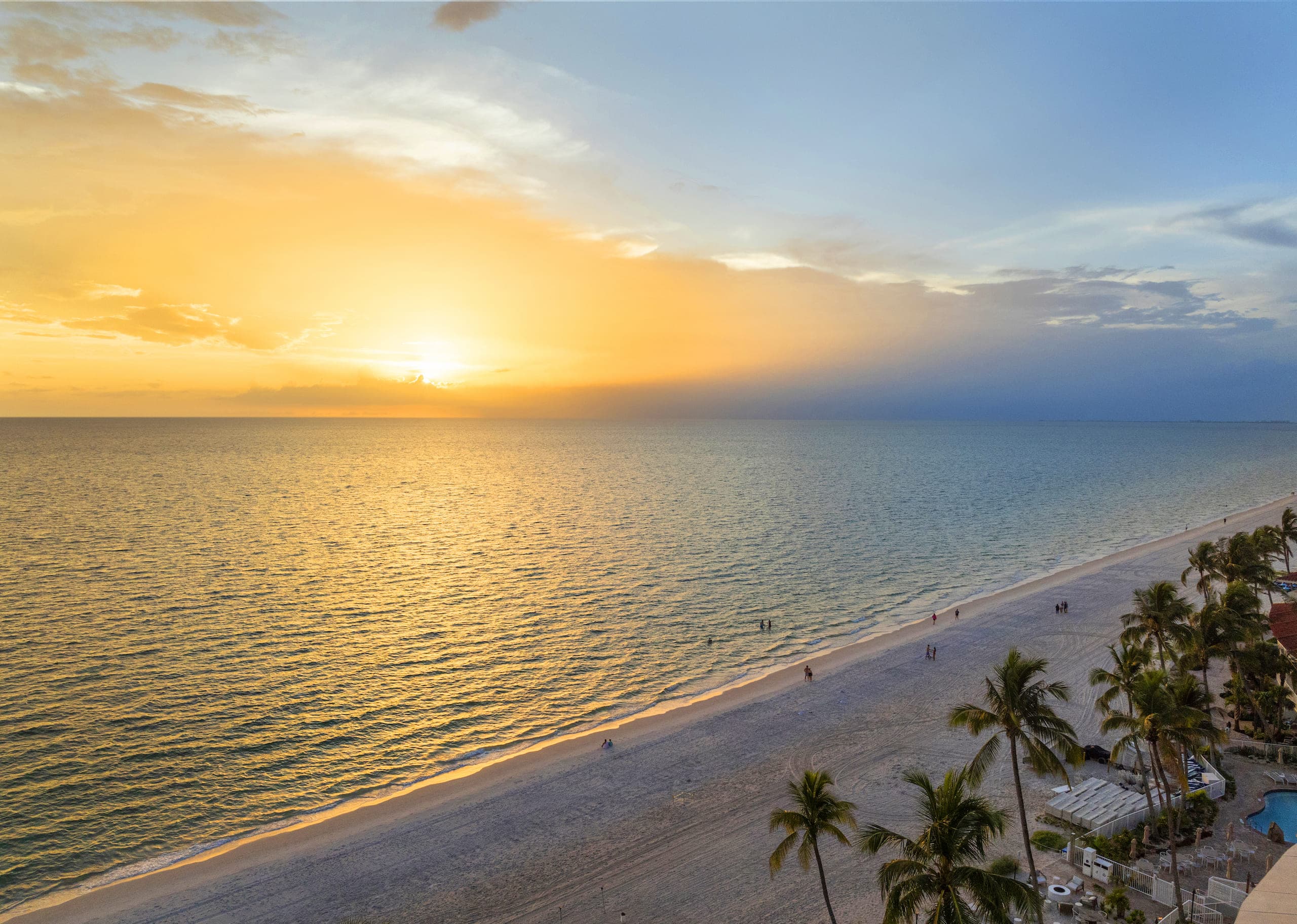 The beach front with some swimmers and a beautiful sunset at LaPlaya
