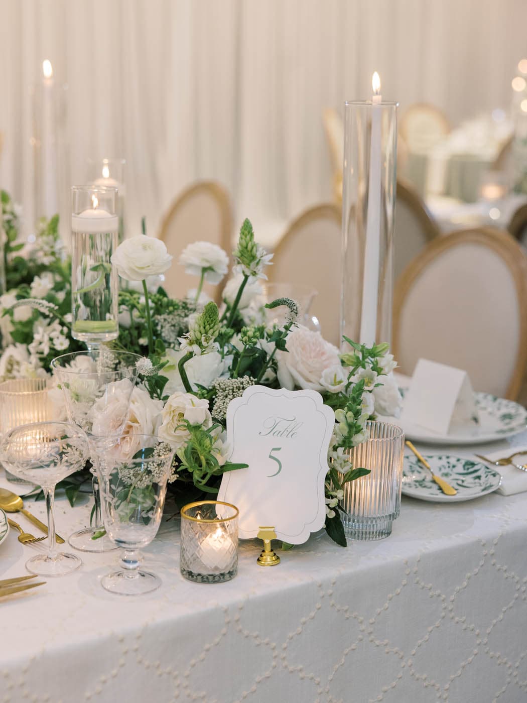 An elegant wedding reception centrepiece arrangement set on a white textured tablecloth