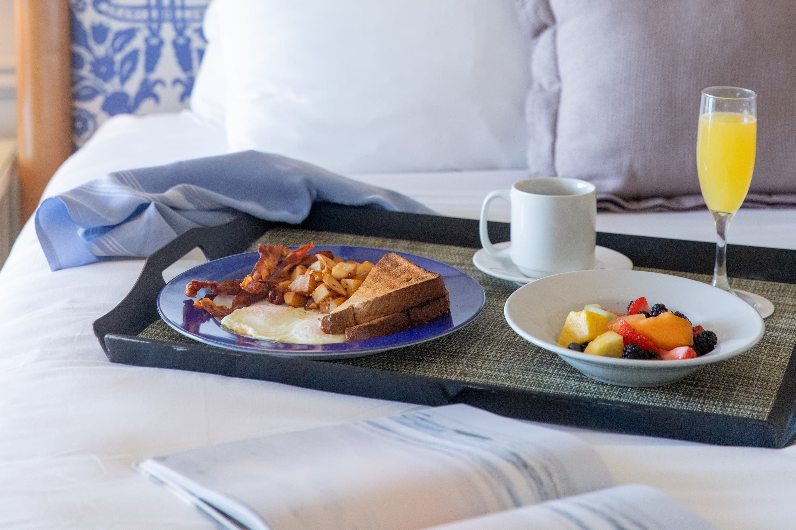 breakfast in bed at LaPlaya, including, bacon, eggs, toast, fruit, coffee, and a mimosa