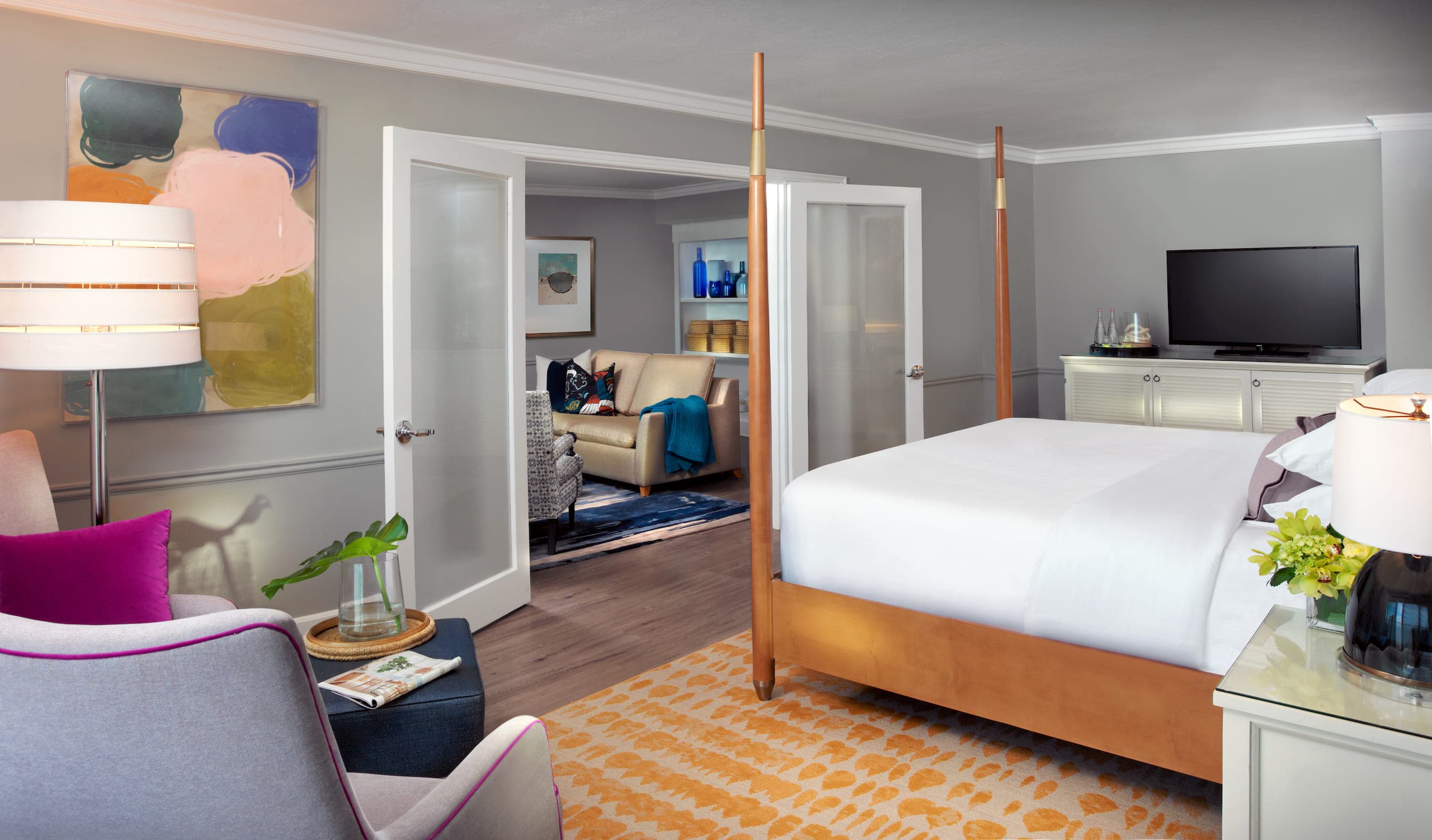 The bedroom with a TV and corner room seating in a Gulf Tower Suite at LaPlaya