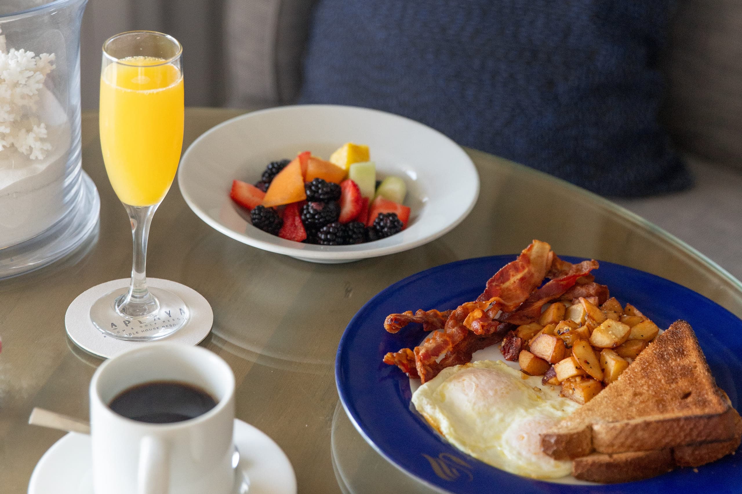 In-room dining breakfast at LaPlaya, including, bacon, eggs, toast, fruit, coffee, and a mimosa