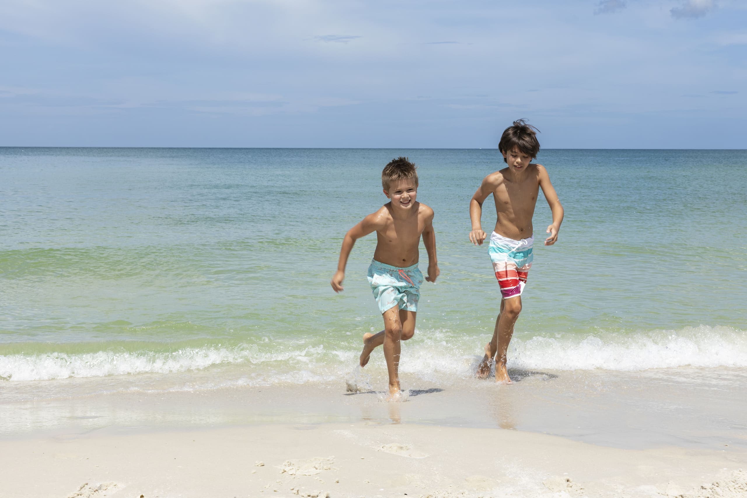 2 kids running on the shore of the beach at LaPlaya