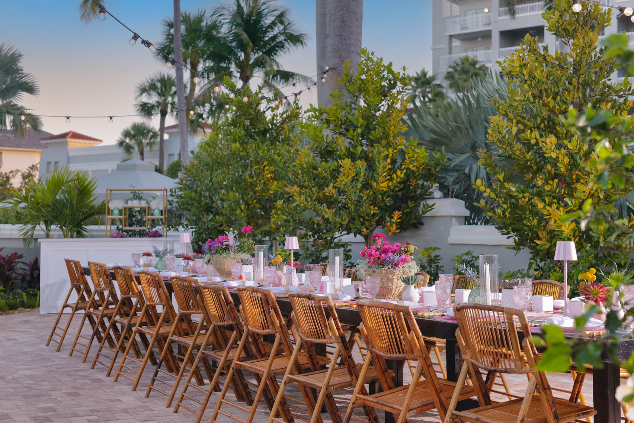 A wooden table setup outside on a patio for a dinner at LaPlaya