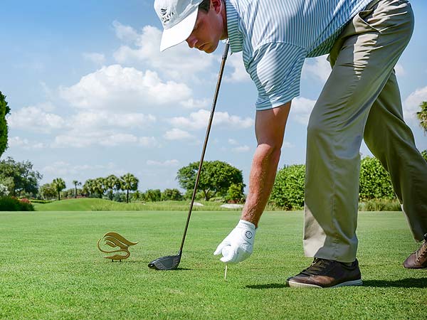 man placing his golf ball on the tee off