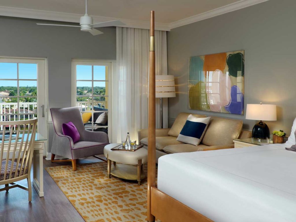 Bayside room with king sized bed, sitting area, desk, and balcony