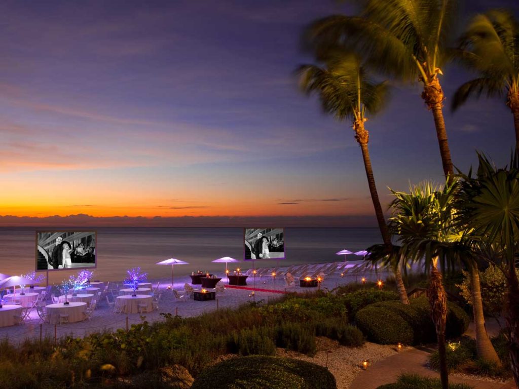 North Beach Event with tables and video screens on beach in Naples, FL
