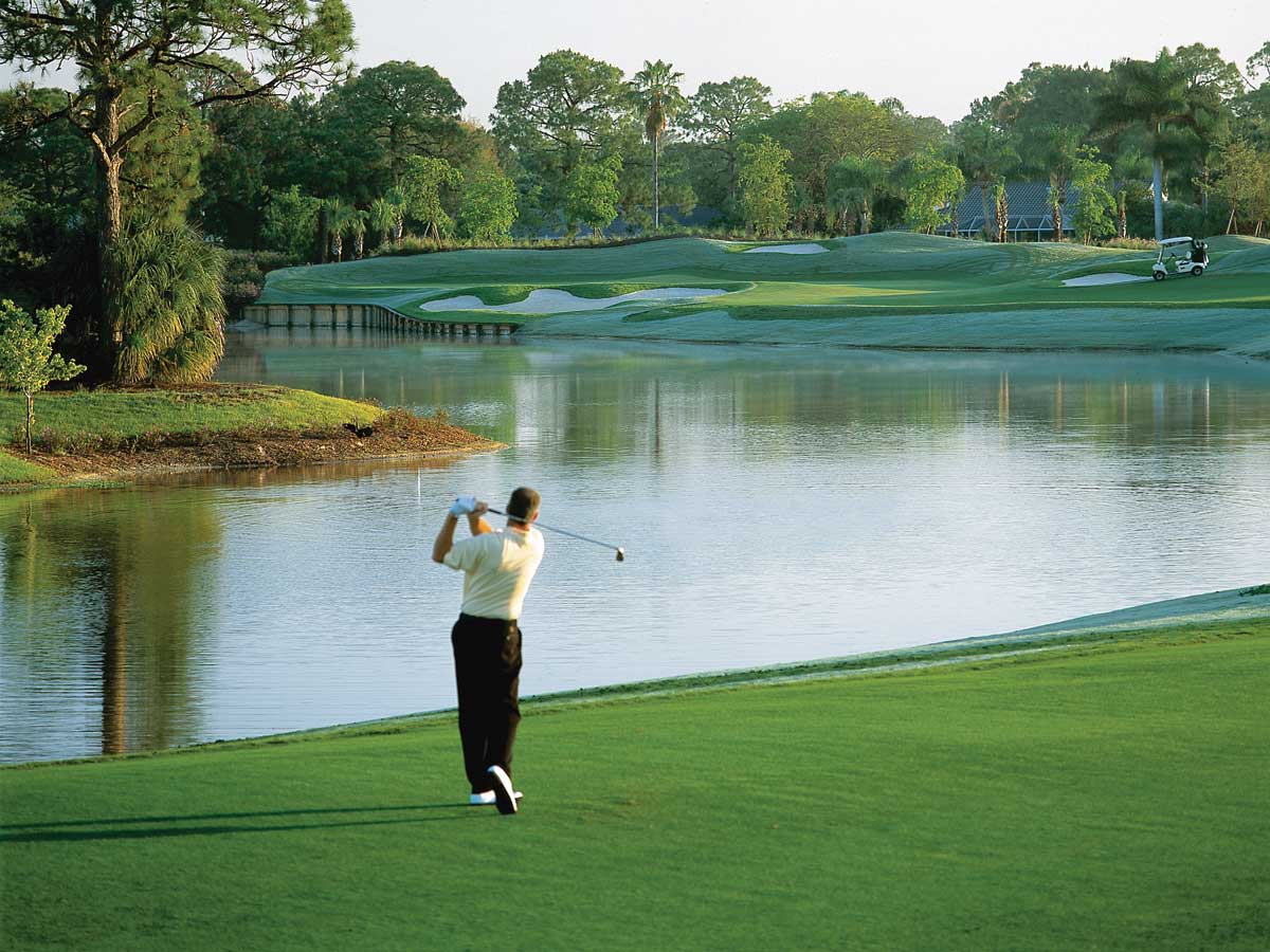Golfer Golfing Over Pond at Naples Florida Golf Course