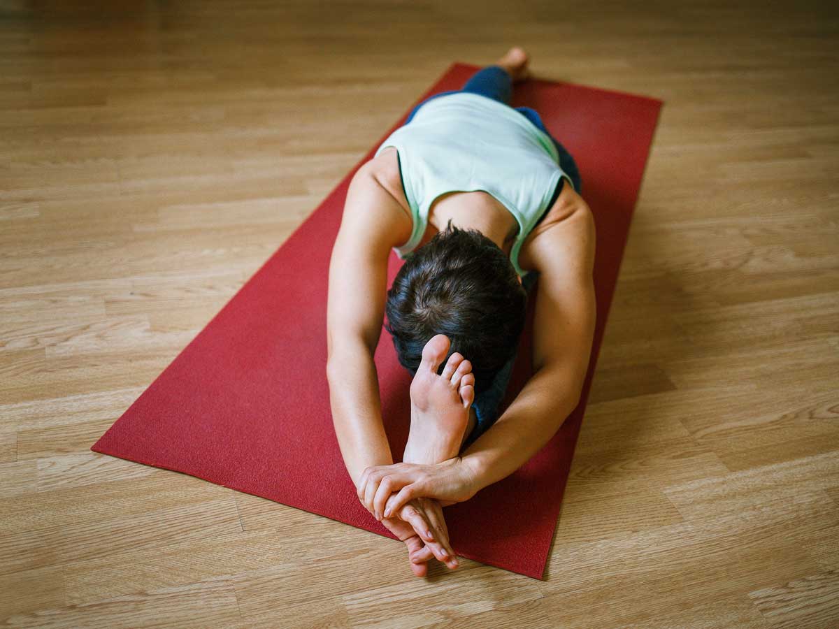 Woman stretching during yoga at La Playa Beach and Golf Resort