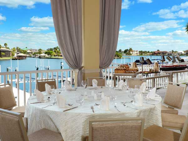 Dining table set up on the terrace by the ocean.