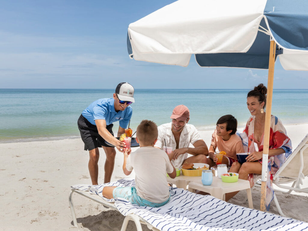 Beach Attendant Serving A Family On The Beach
